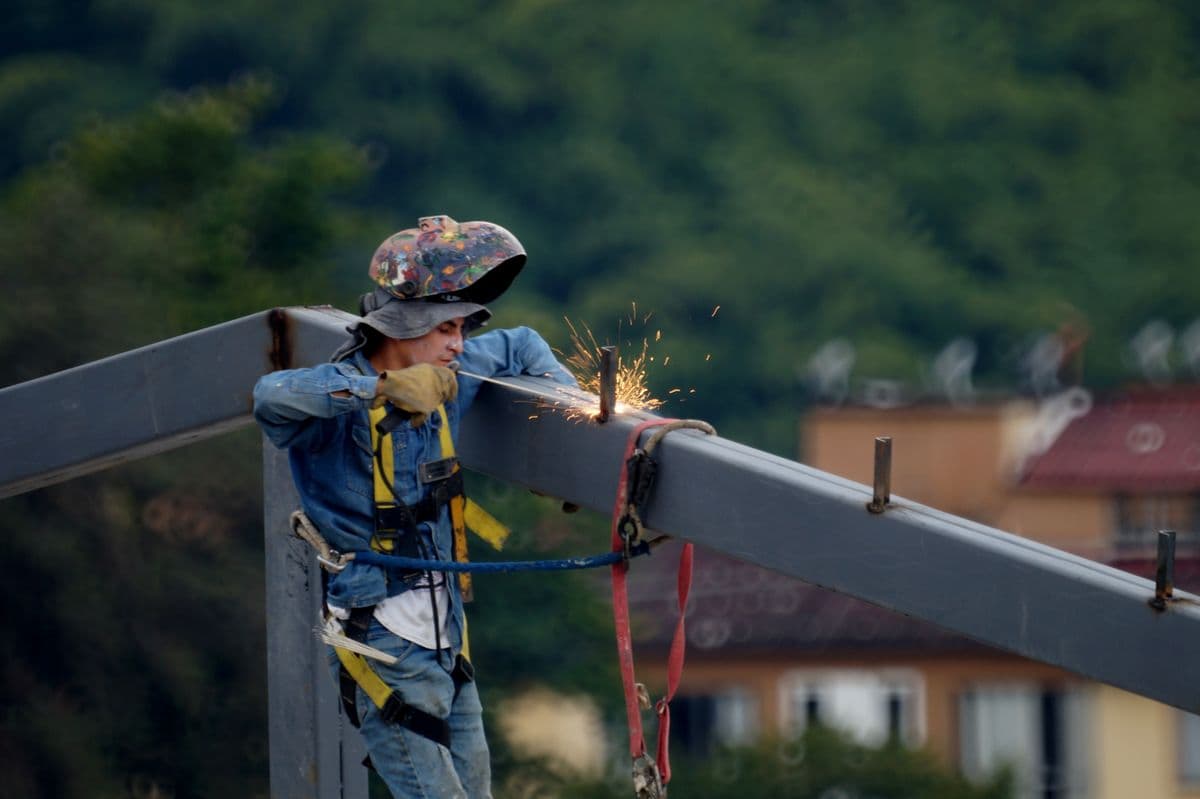 Worker wearing fall protection harness on a construction site