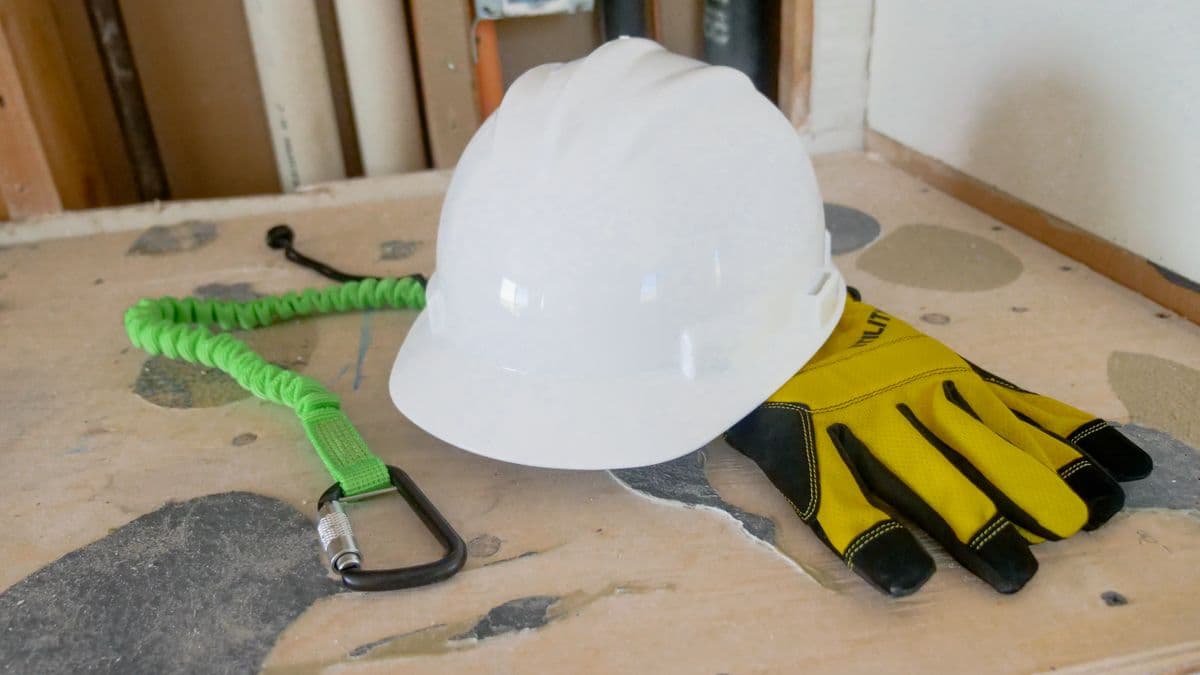 Construction worker wearing full PPE including hard hat, safety glasses, gloves, and high-visibility vest