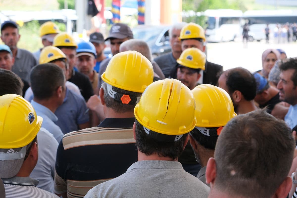 Construction crew in hard hats gathered for a toolbox talk safety meeting on a job site