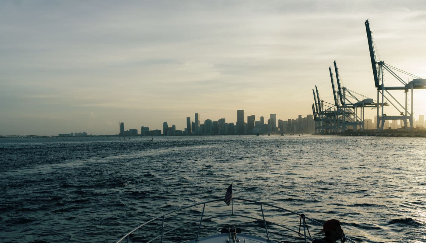 Miami, Florida skyline and port with construction cranes at sunset