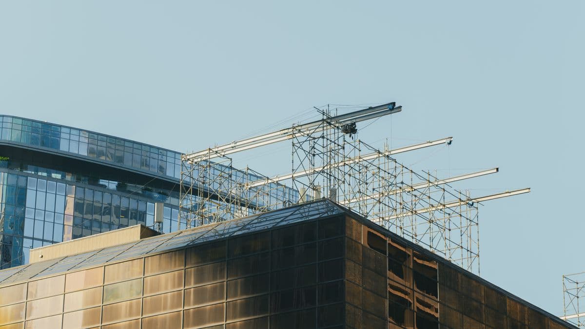 Modern glass skyscraper with scaffolding and cranes in Houston, Texas